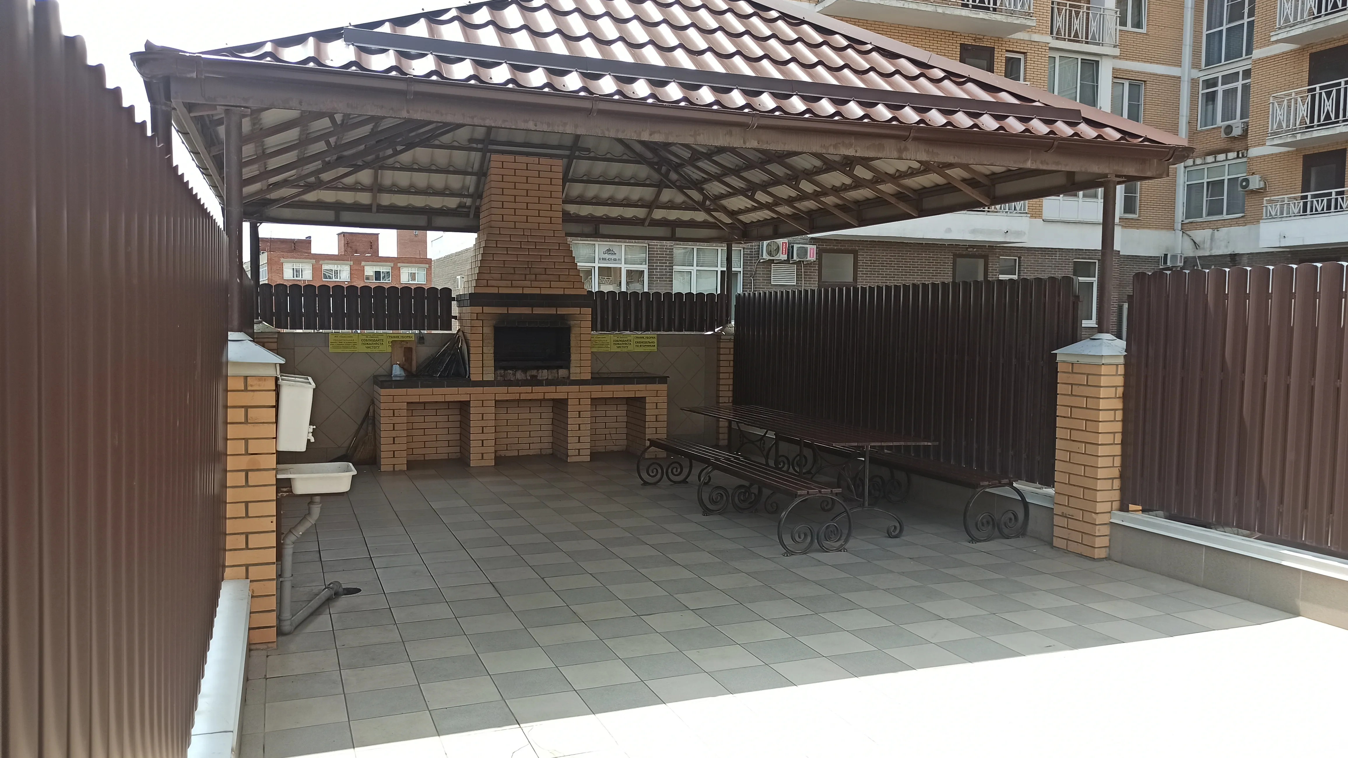 Вид внутри беседки со столом и скамейками